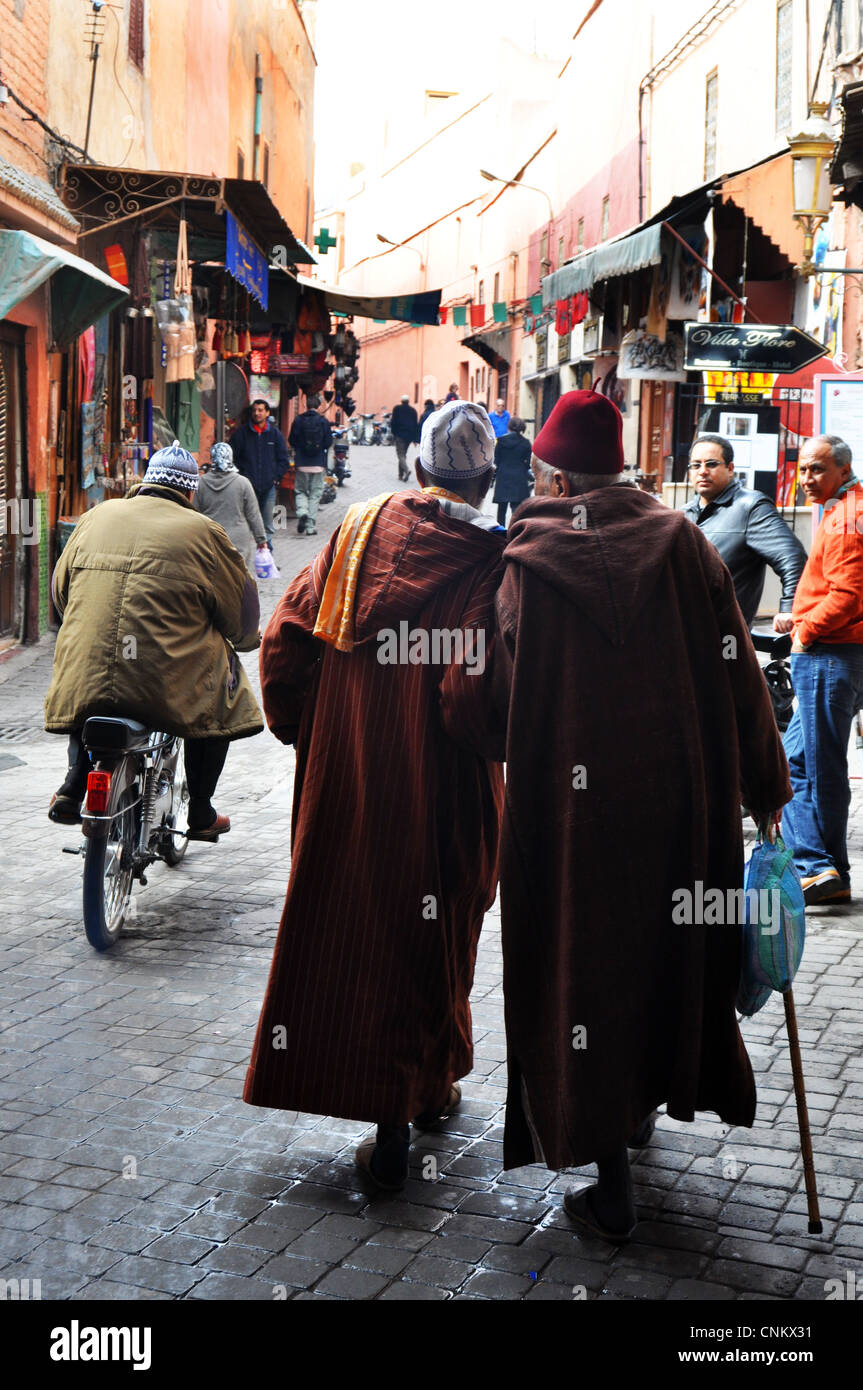 Two elderly men walk hand in hand through the Medina Marrakesh, Morocco Stock Photo