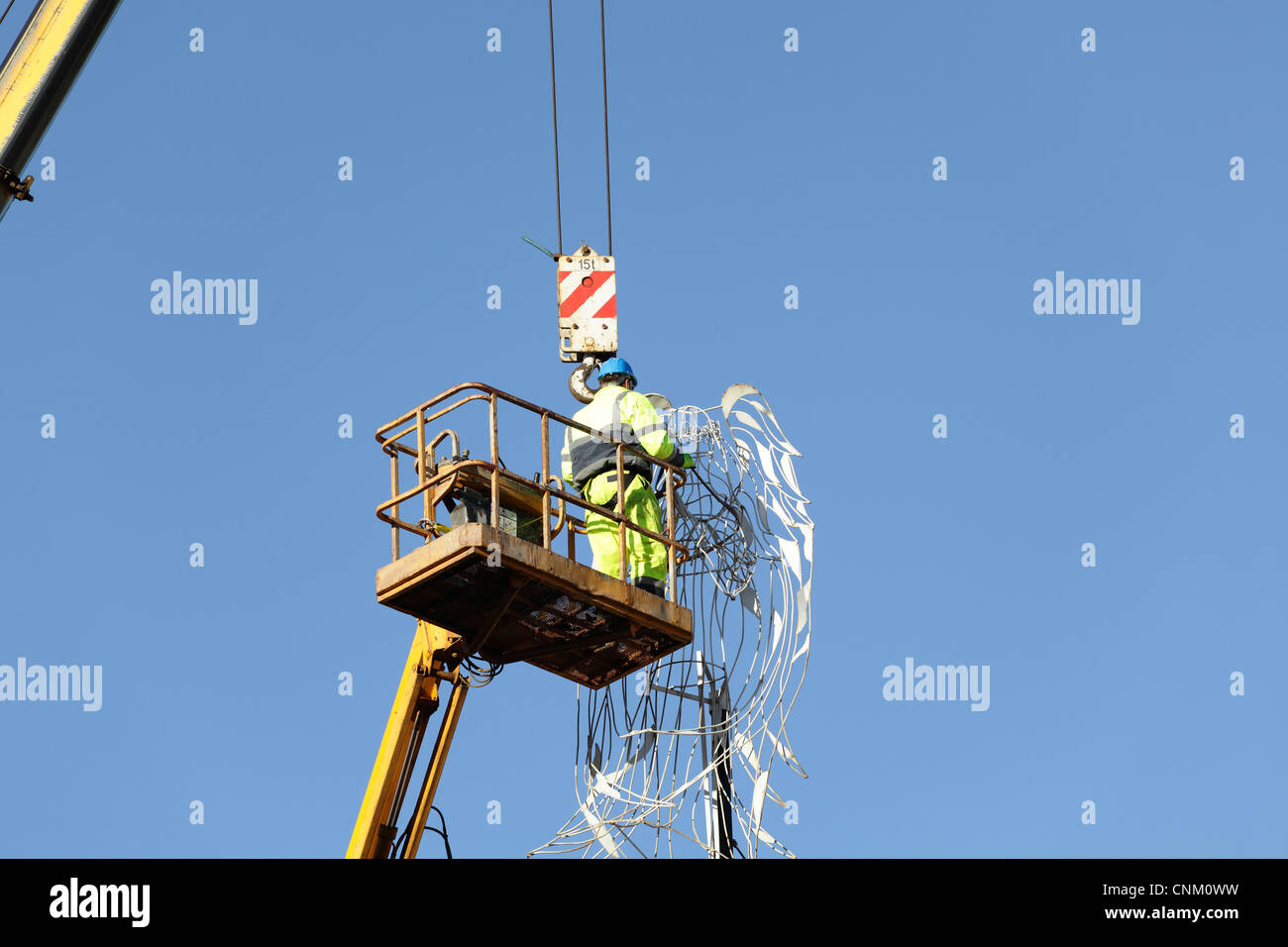Workman using a crane and hoist to remove Christmas lights and decorations, UK Stock Photo Alamy