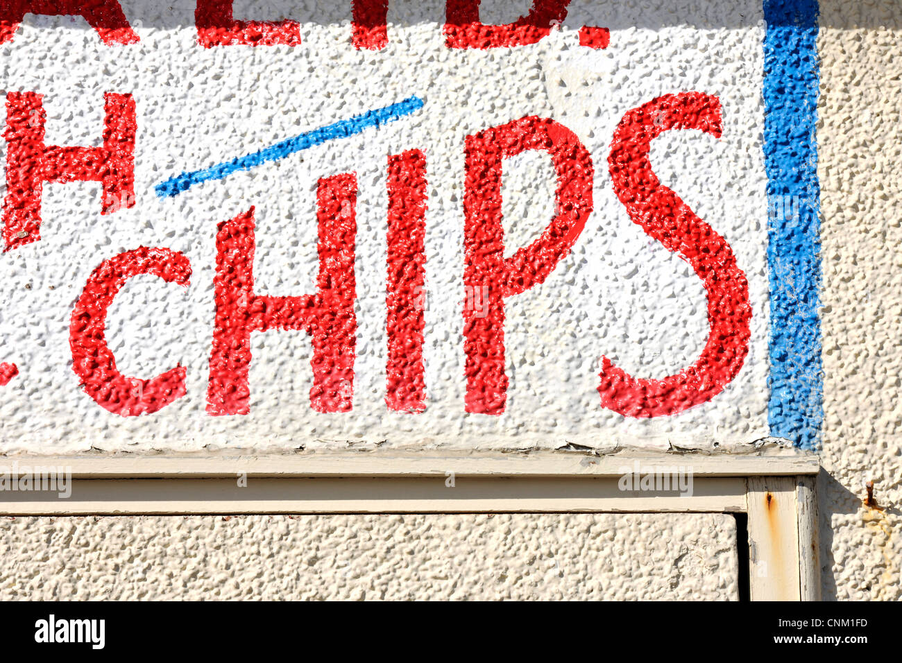 Close-up of sign saying Chips in red letters on pebble dashed cream painted wall Stock Photo