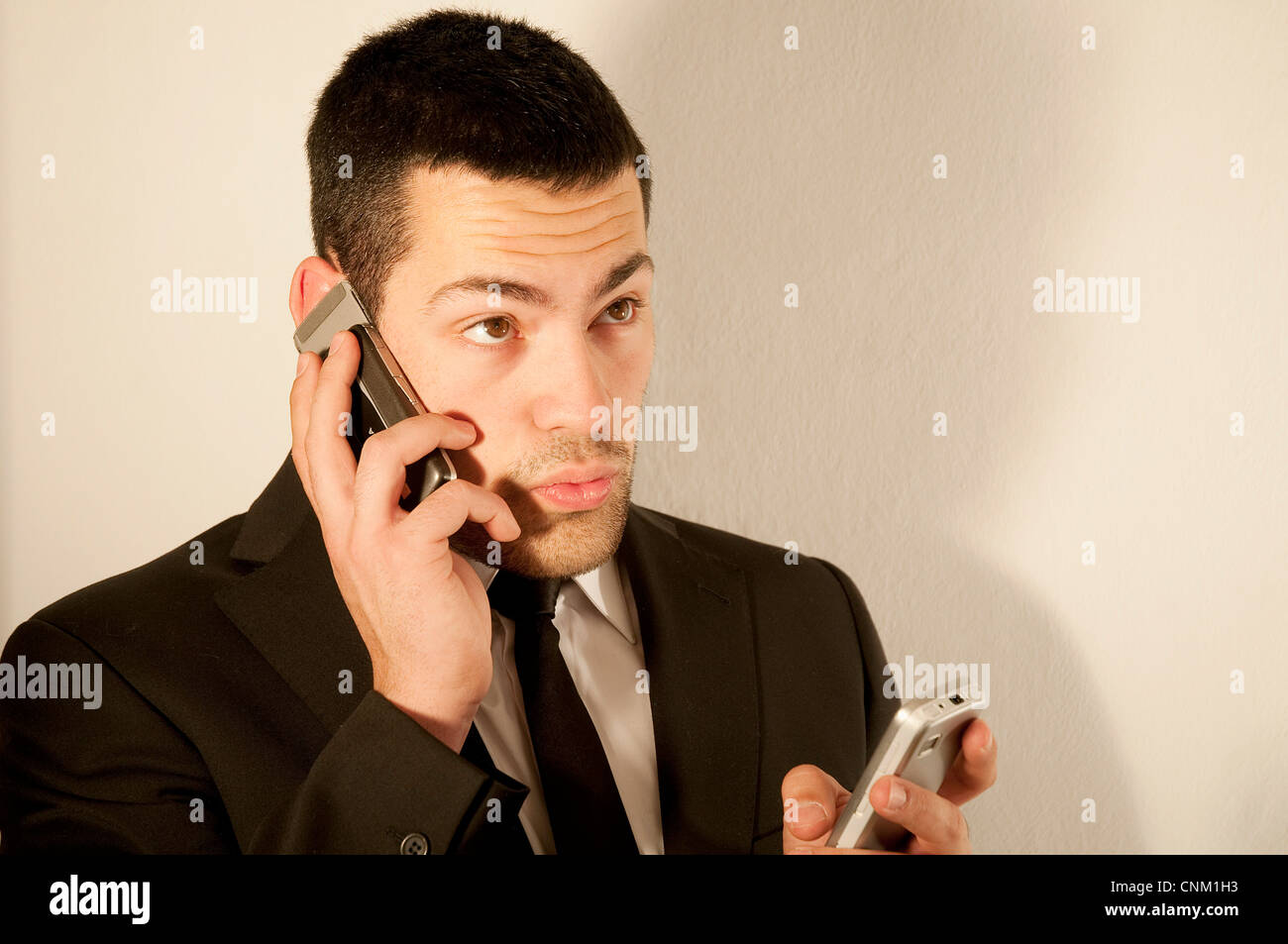 Young man using two mobile phones. Stock Photo