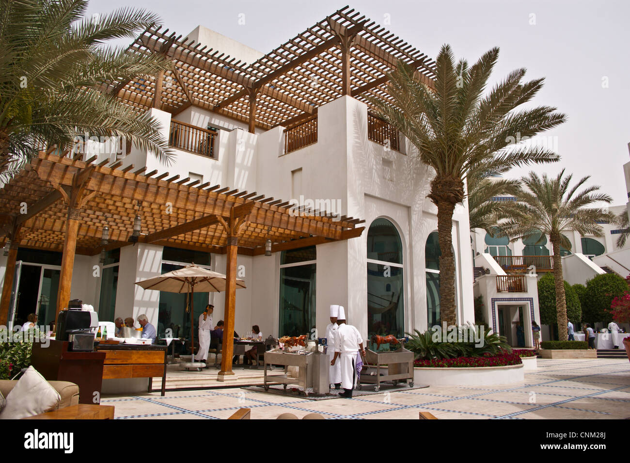 Two chefs serve roast pork from a rotisserie, Friday Brunch at Park