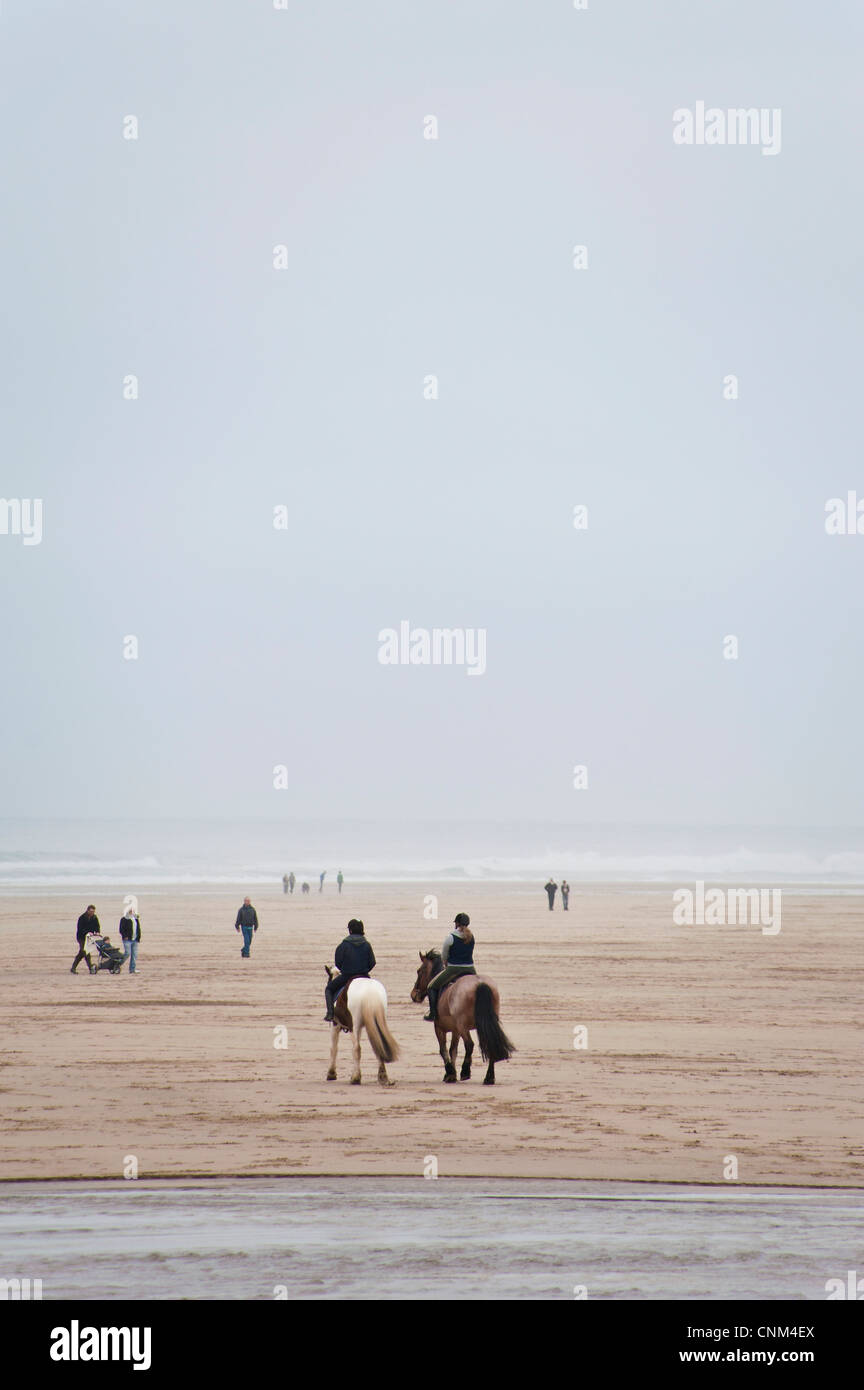Two women riding horses on a sandy beach Stock Photo - Alamy