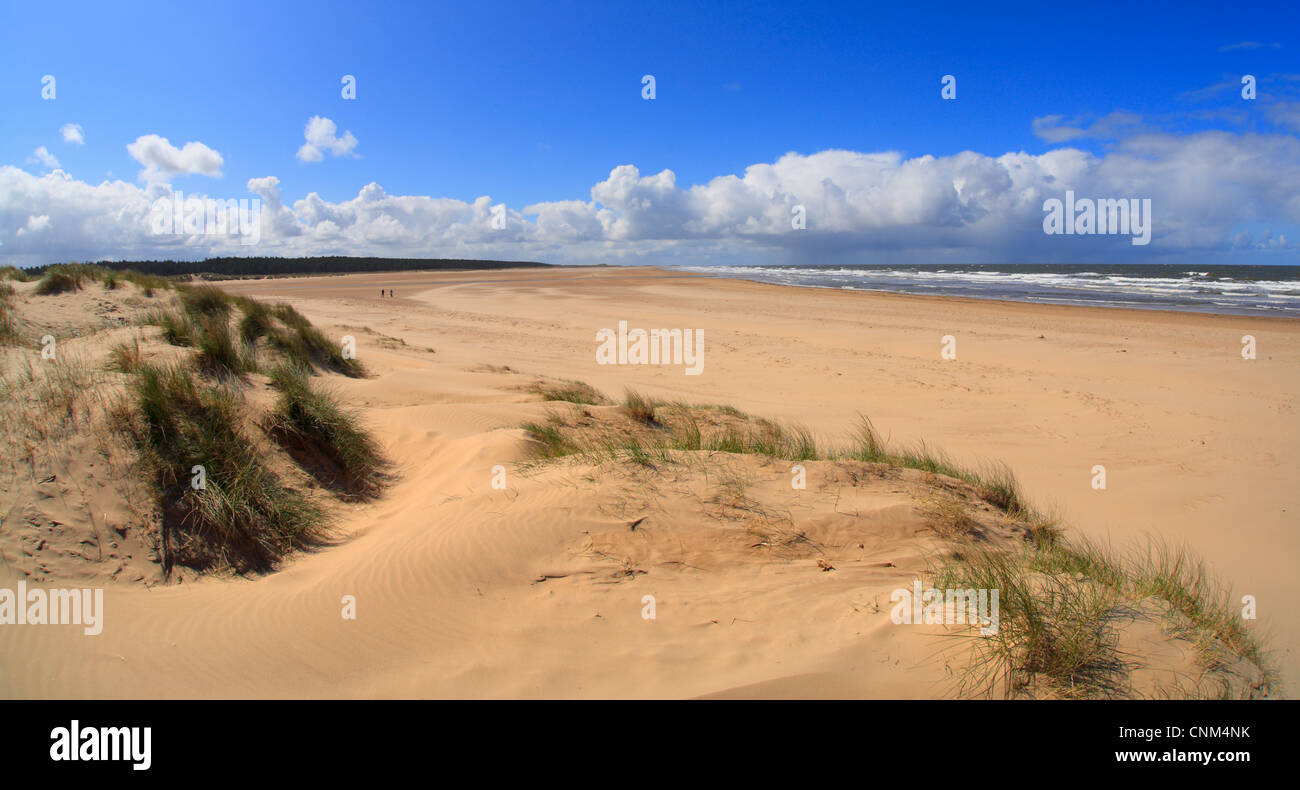 Sands and sea at Holkham Bay on the North Norfolk coast. Two very distant figures on the beach. Stock Photo