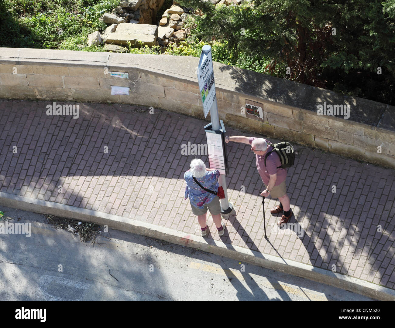 Retired couple waiting for bus Qawra, Malta, Europe Stock Photo