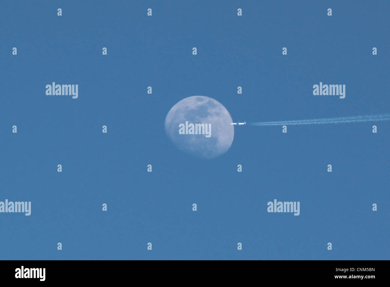 Plane in the sky against full moon during day time Stock Photo