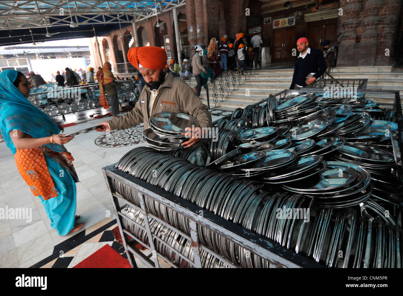 Asia India Punjab Amritsar Golden Temple or Hari Mandir An attendant distributes dishes to the food Stock Photo
