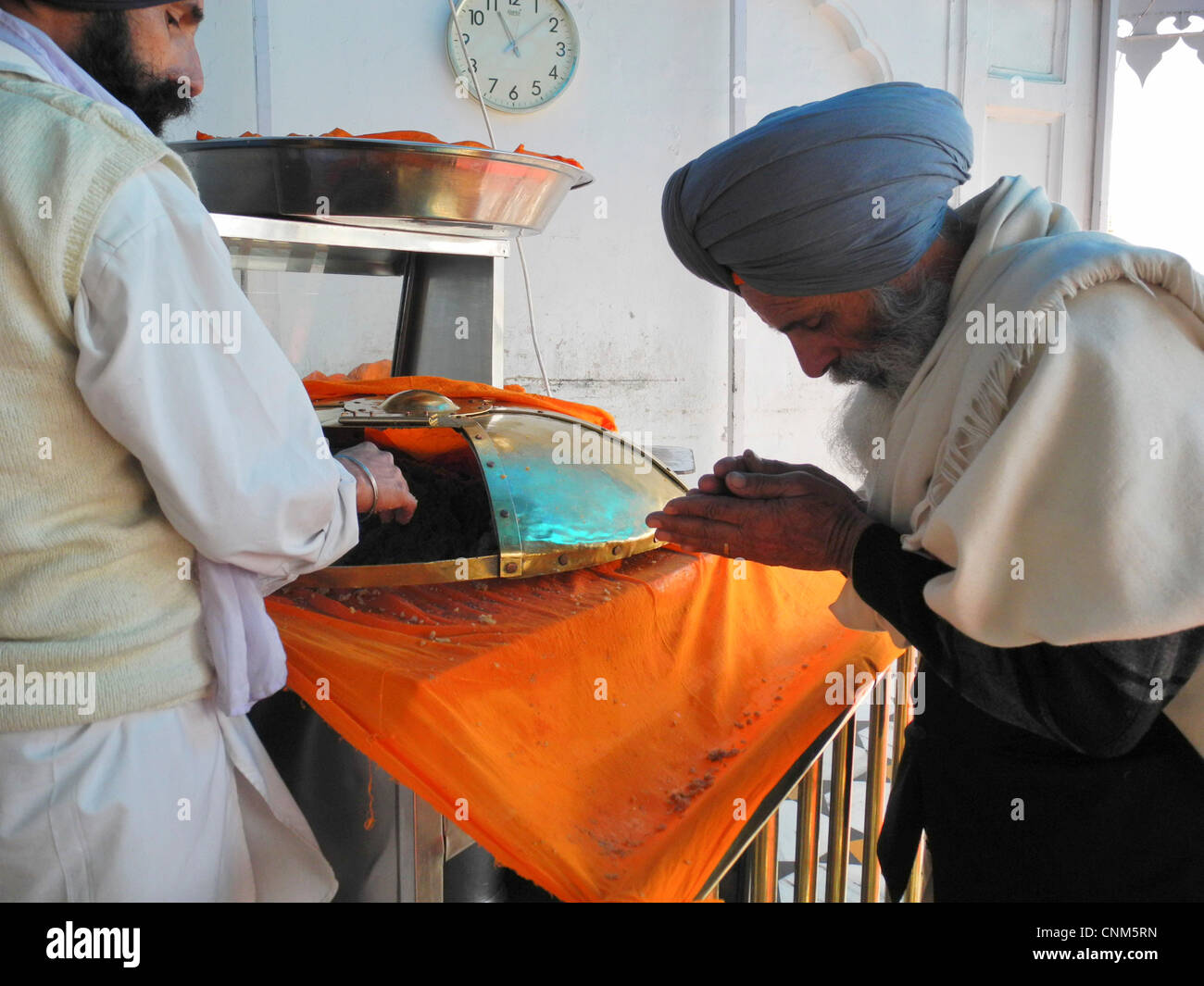 India Punjab Amritsar Golden Temple or Hari Mandir Inside the temple a pilgrim receives the soft and sweet prasad or food supply Stock Photo