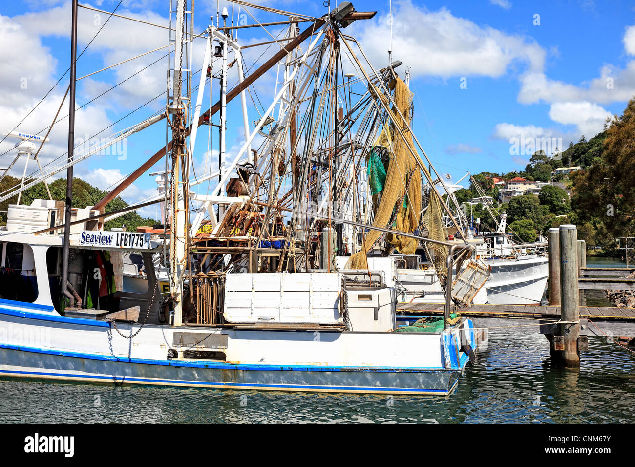 Fishing boats at rest in river estuary moored at a pier Stock Photo Alamy
