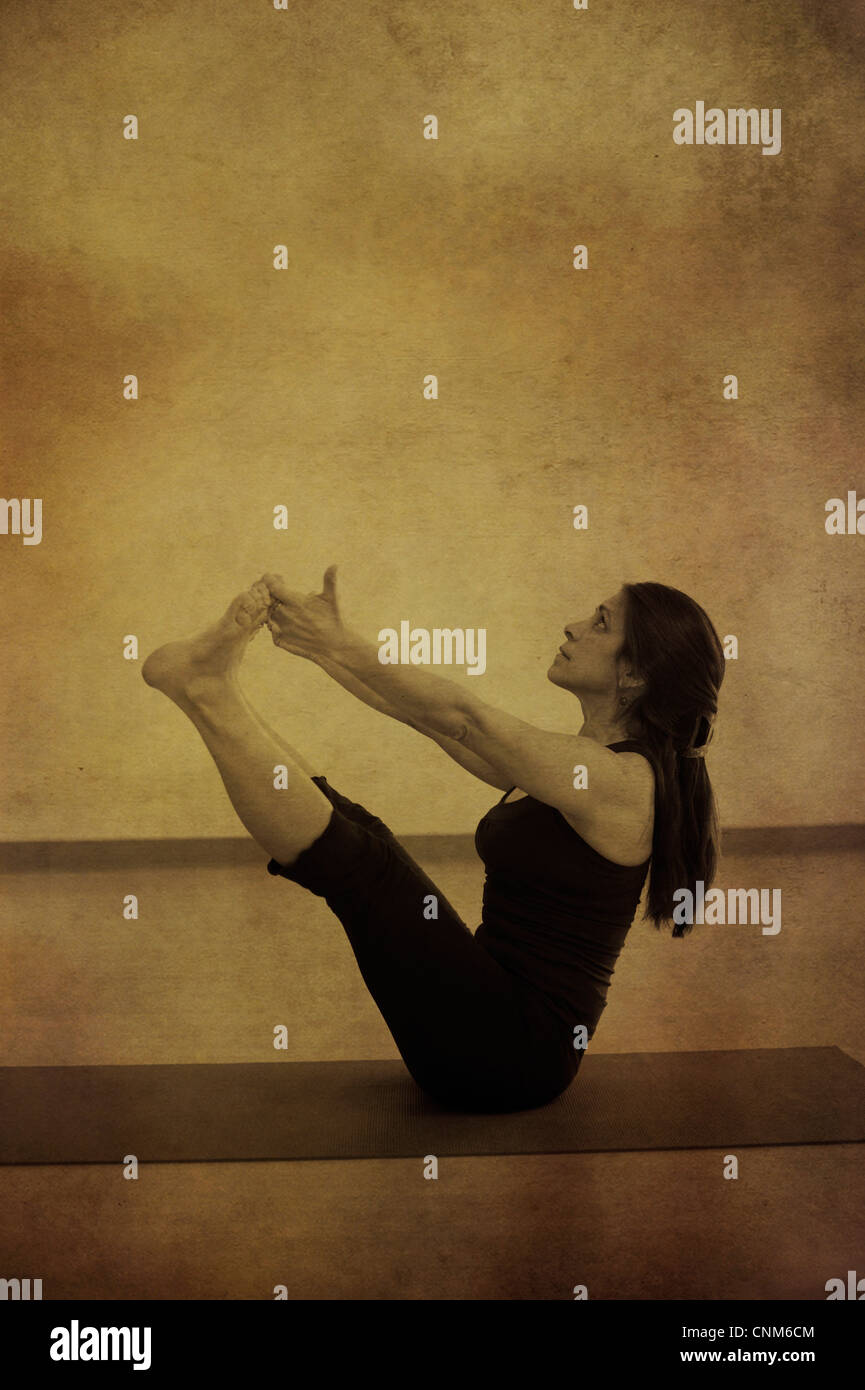 Woman in supported yoga navasana pose or boat pose Stock Photo - Alamy