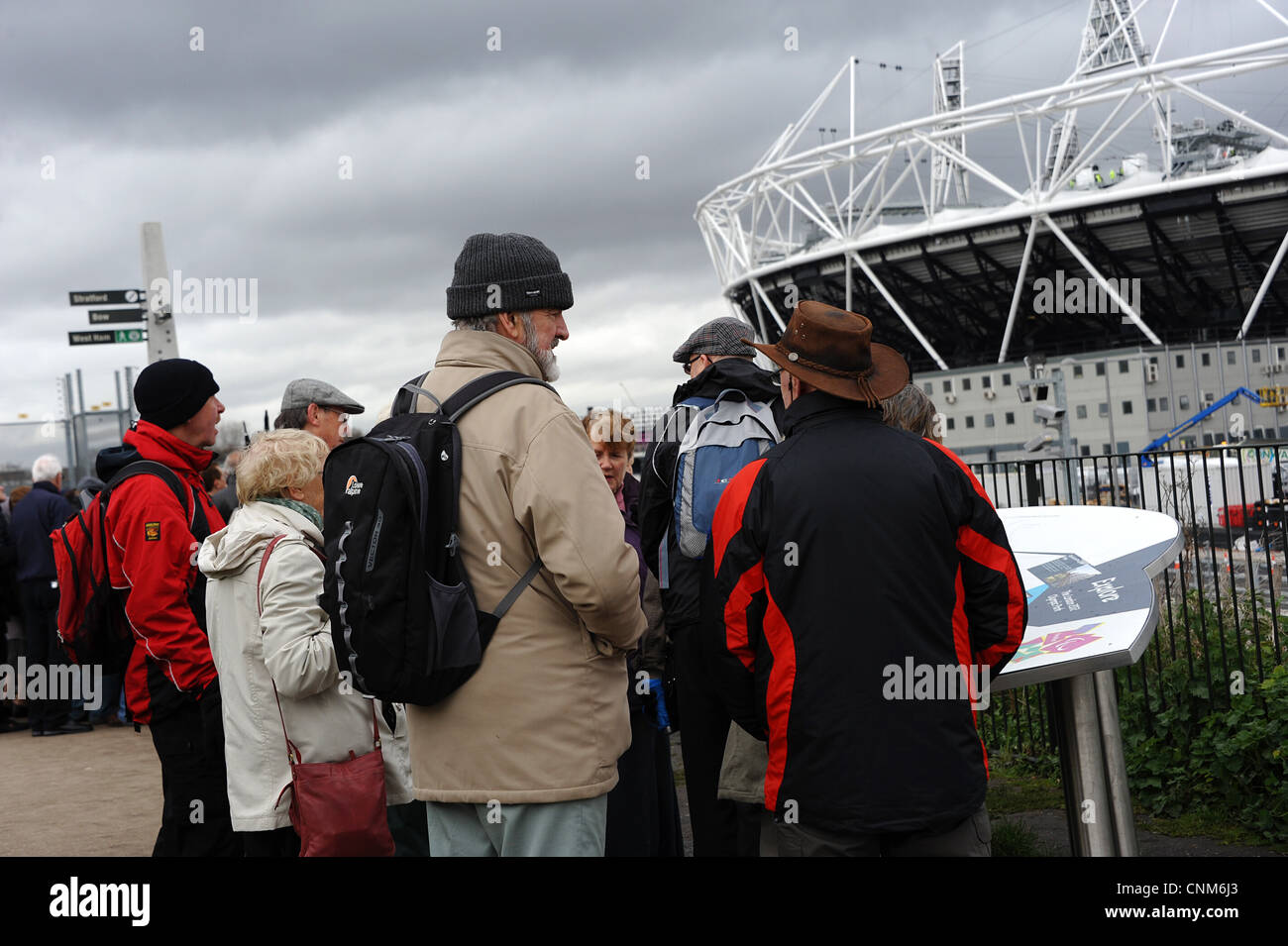 A group of interested tourists on the Greenway viewing the 2012 Olympic Stadium,  Stratford, East London. Stock Photo