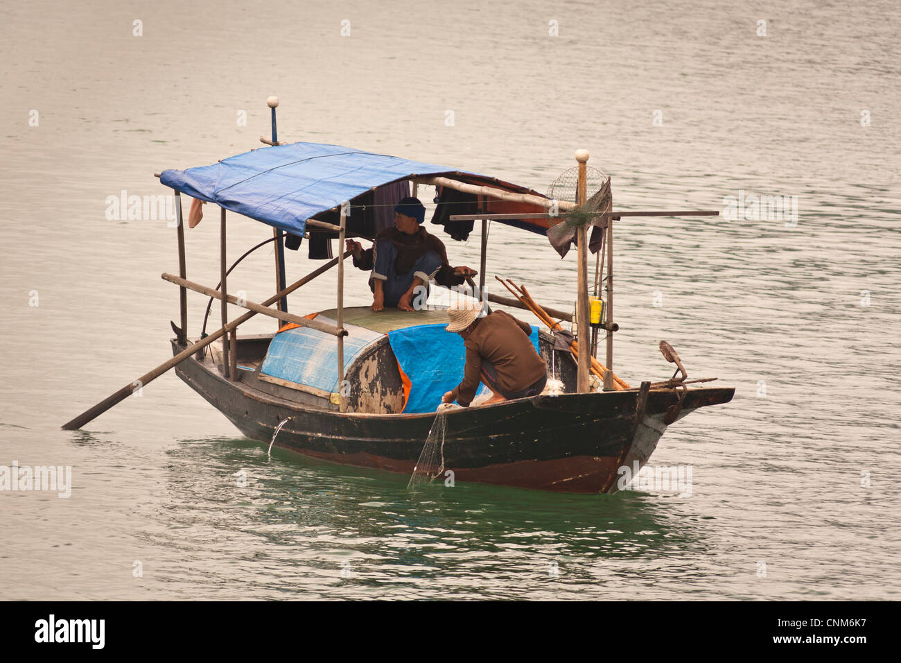 Two fishermen fishing in a small boat, Halong Bay, Quang Ninh, Vietnam Stock Photo