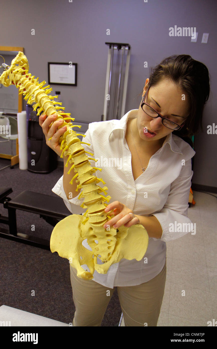 Miami Beach Florida,physical therapist,model,spinal column,vertebrae,pelvic bones,pelvis,explains ruptured,herniated,FL120311073 Stock Photo