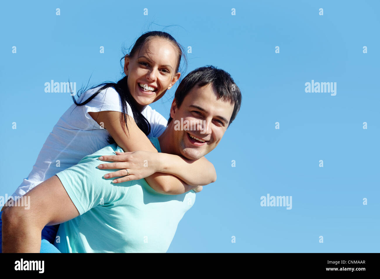 Portrait of a young couple against blue sky Stock Photo - Alamy