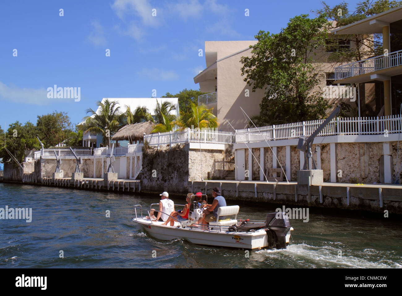 Florida Upper Key Largo Florida Keys,Largo Sound Canal,waterfront homes,houses,coralline limestone late Pleistocene reef complex,outboard motorboat,bo Stock Photo