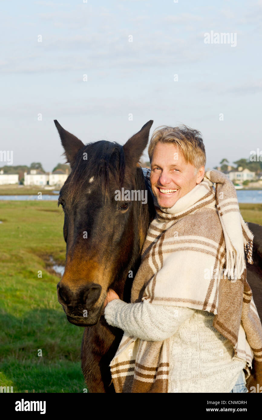 A portrait of a happy smiling forties man with his horse. Stock Photo