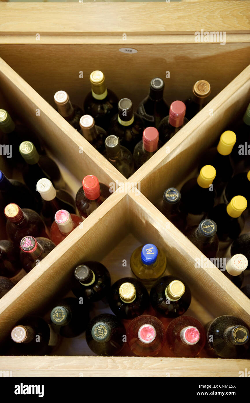 box or crate or shelf of wine showings bottles and coloured tops Stock Photo
