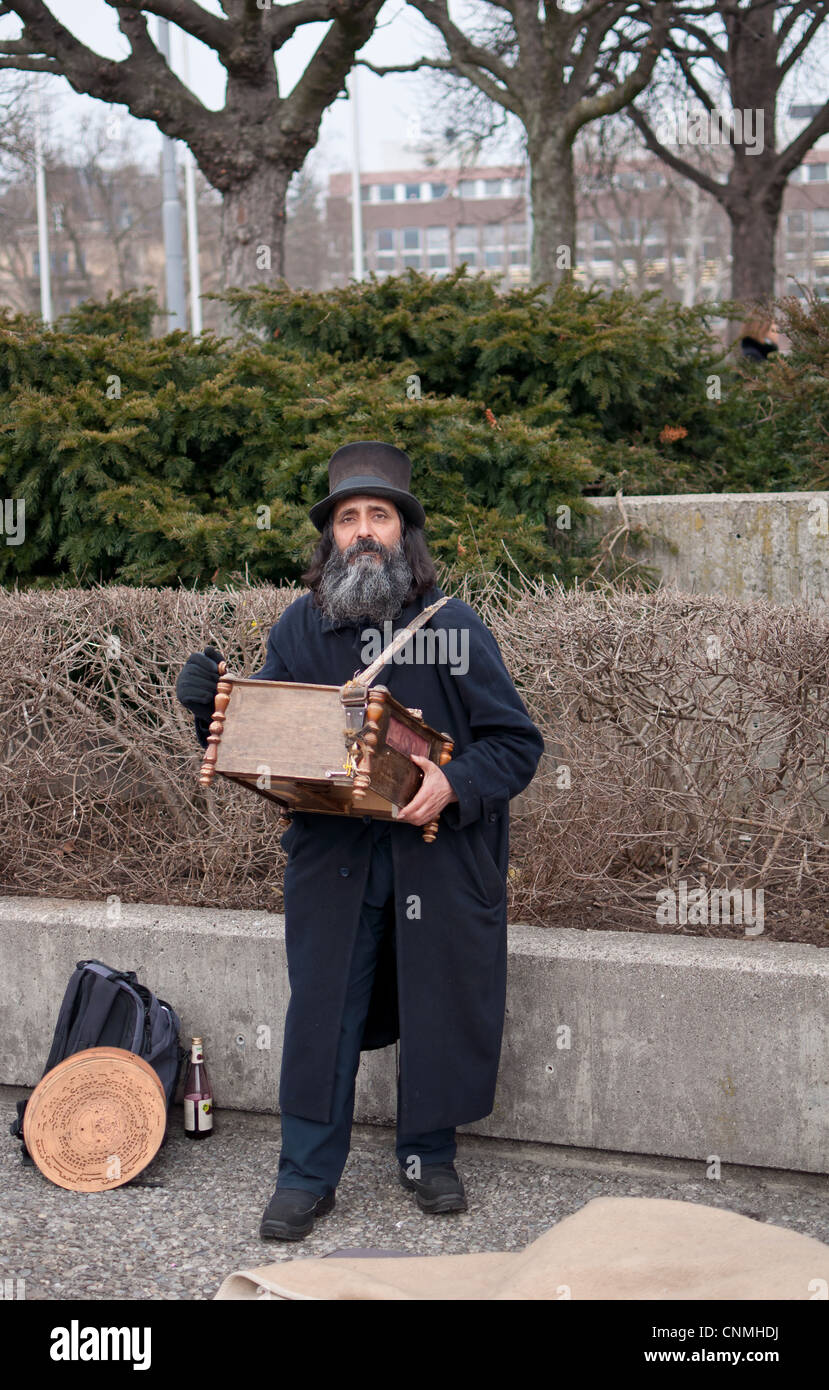 Street artist plays music with an ancient perforated disc player. Stock Photo