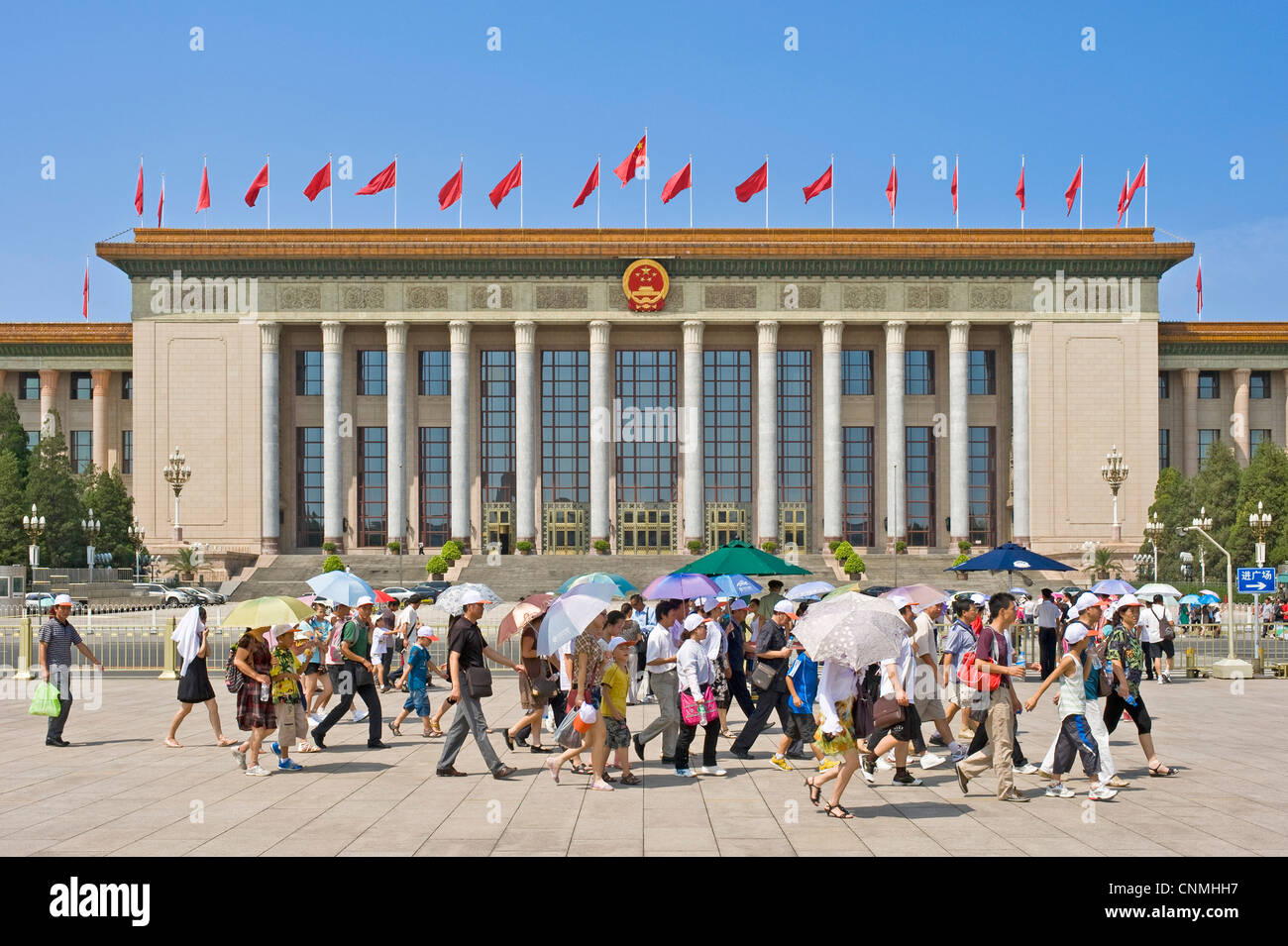 Chinese tourists in Tiananmen Square with The Great Hall of the People in the background. Stock Photo