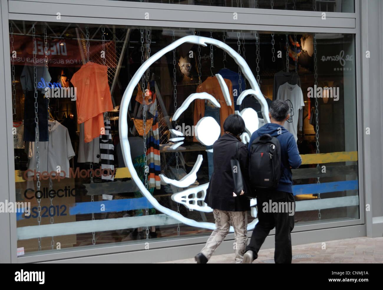 A couple passing a drawing of a skull like face on Cheap Monday boutique  window,Carnaby St, London, UK Stock Photo - Alamy