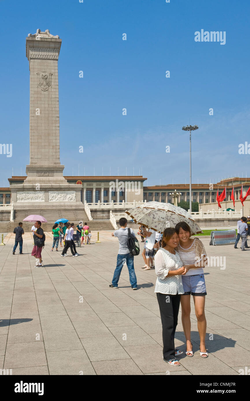 Chinese tourists in Tiananmen Square taking photographs of each other with The Monument to the People's Heroes and The Great Hal Stock Photo