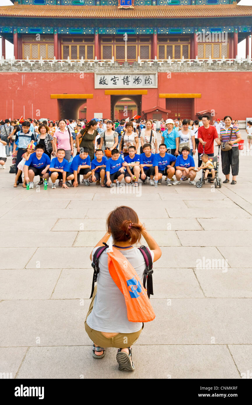 Tourists taking photographs of each other outside the Gate of Divine Prowess (main exit) of the Forbidden City. Stock Photo