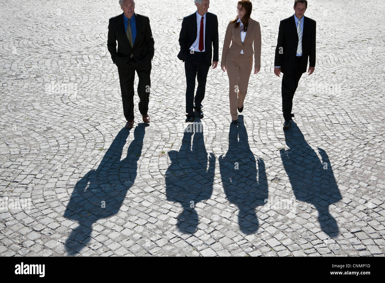 Business people walking on cobbled road Stock Photo