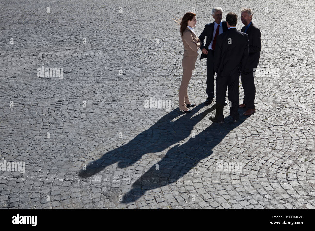 Business people talking on cobbled road Stock Photo