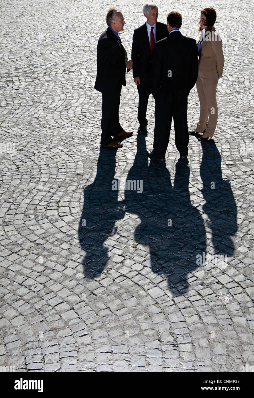 Business people talking on cobbled road Stock Photo