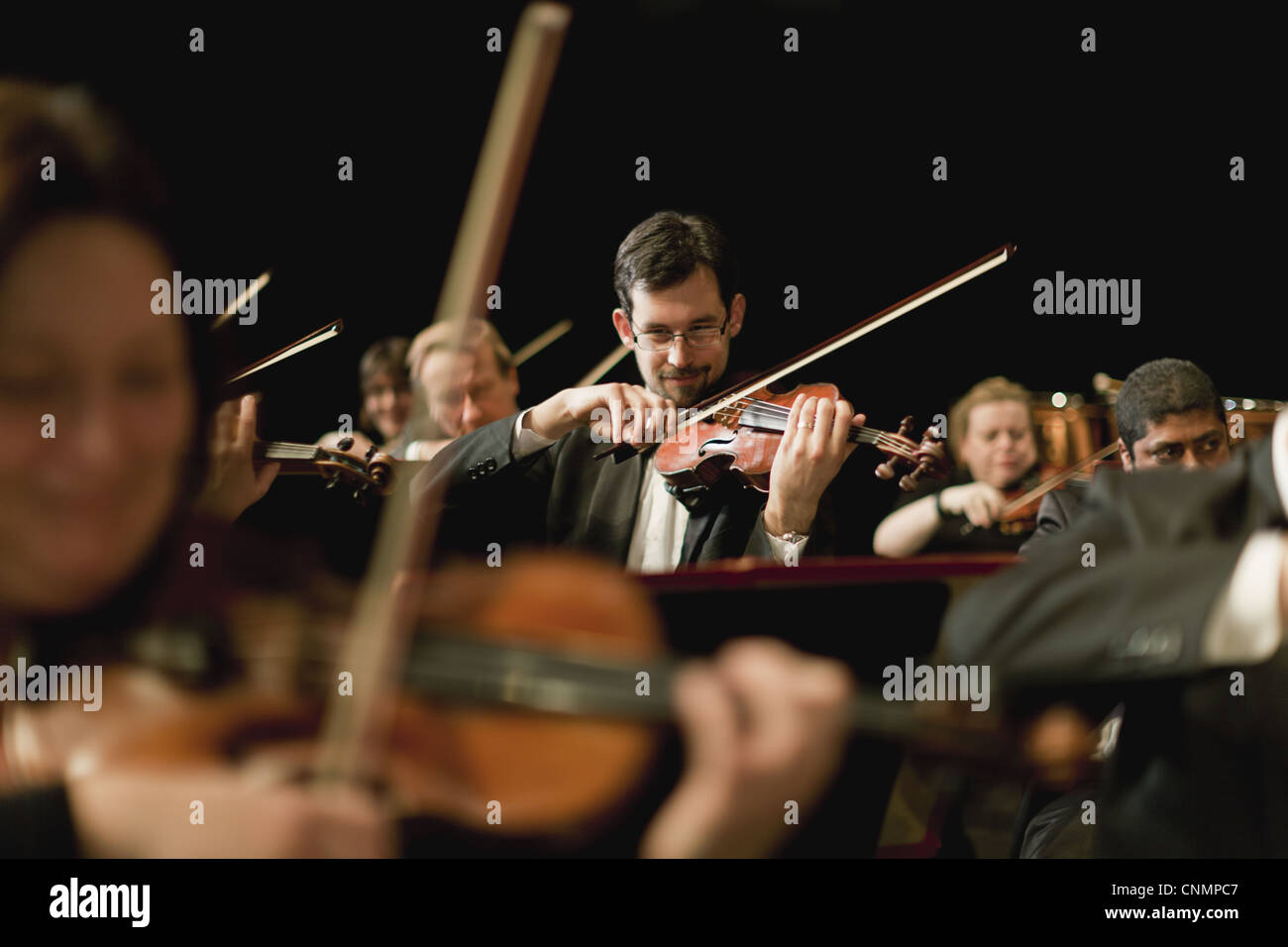 Violin players in orchestra Stock Photo