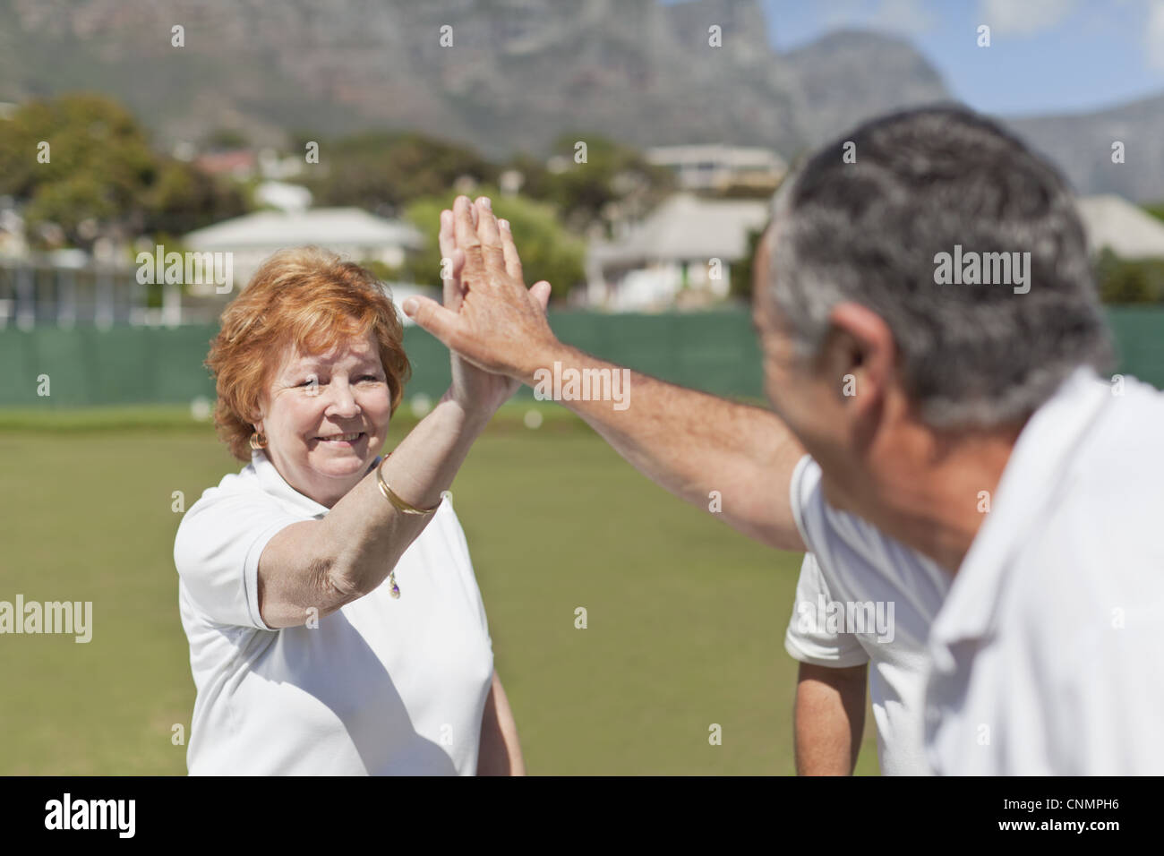 Older couple high fiving outdoors Stock Photo