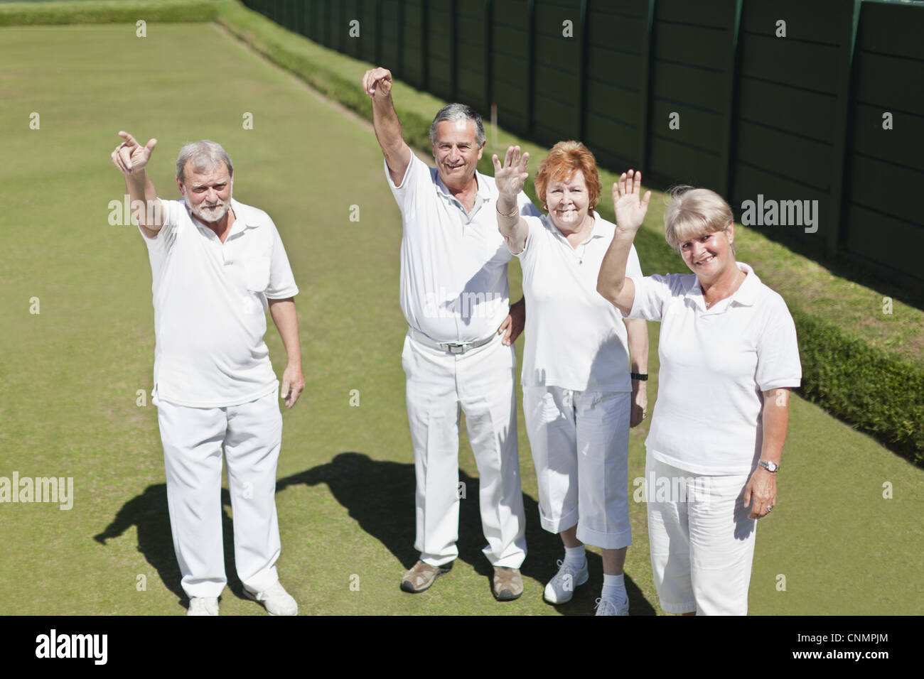 Older people waving from lawn Stock Photo