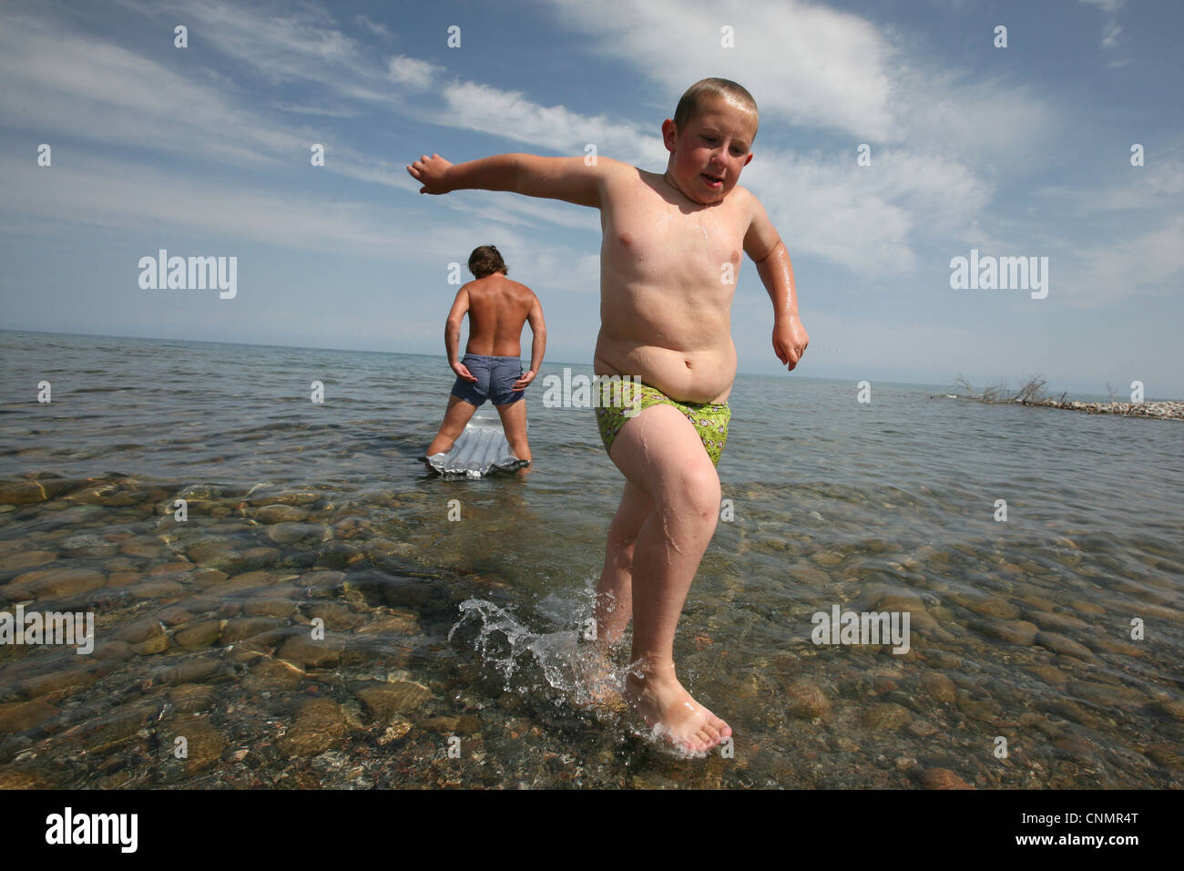 Young boy at the beach on Issyk Kul Lake, Kyrgyzstan. Stock Photo