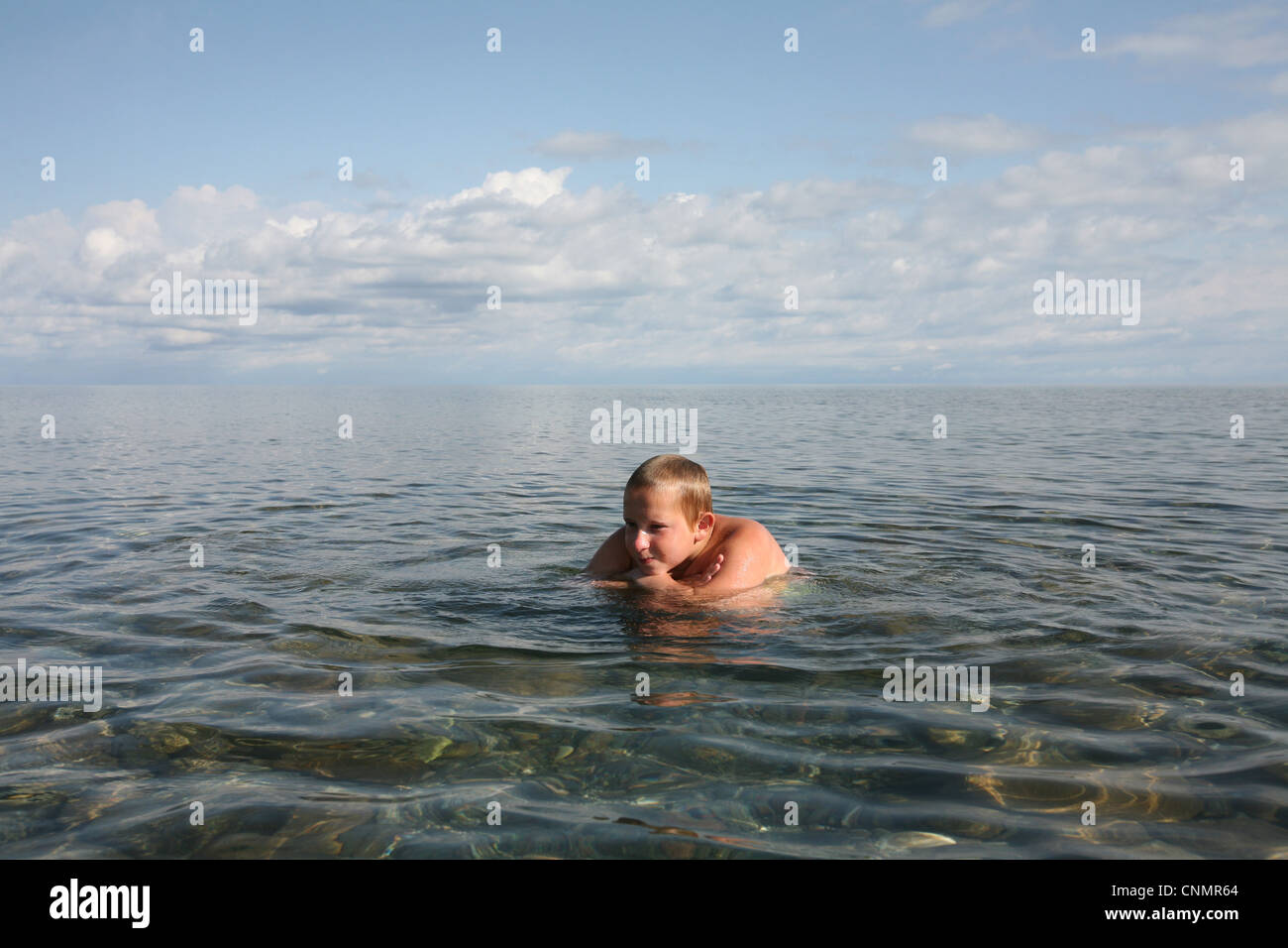 Young boy swims in Issyk Kul Lake, Kyrgyzstan. Stock Photo