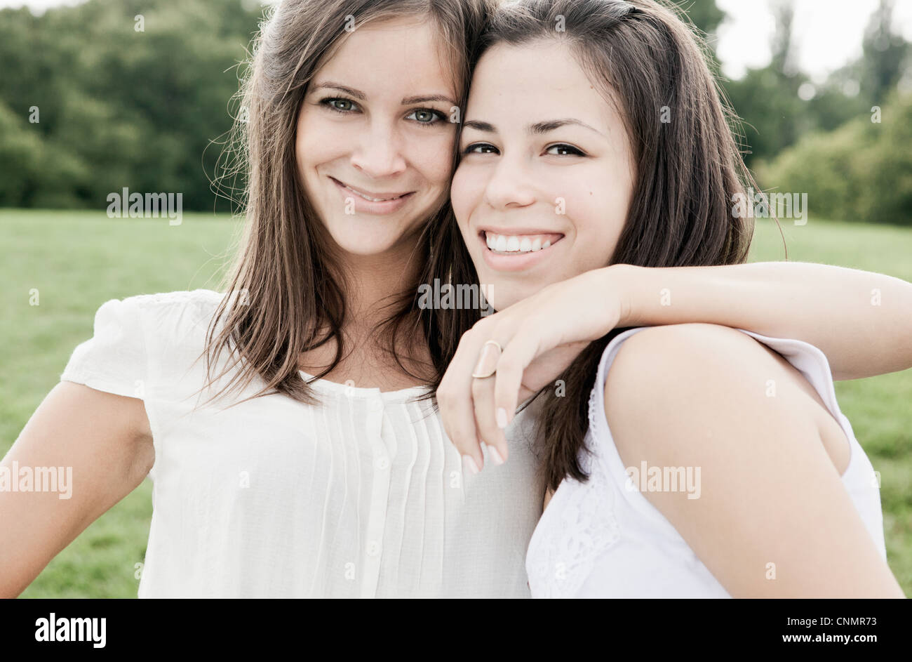 Smiling women hugging outdoors Stock Photo - Alamy