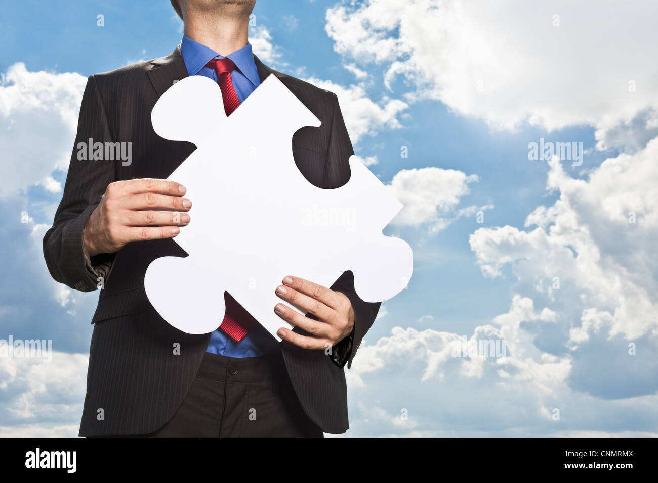 Businessman holding puzzle piece Stock Photo