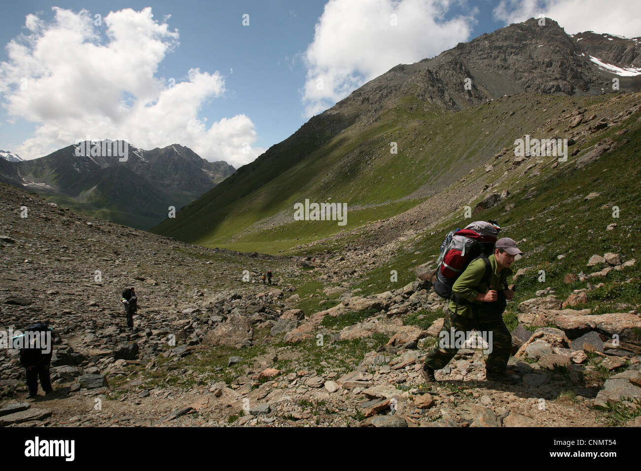 Trekkers climb up to Telety mountain pass (3,759 m) in Terskey Ala-Too mountain range in Tian Shan, Kyrgyzstan. Stock Photo