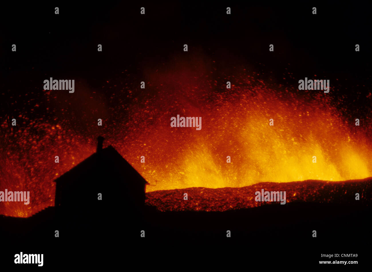 Volcanic eruption, erupting lava with town house silhouetted, Eldfell Volcano, Heimaey, Westmann Isles, Iceland, 1973 Stock Photo