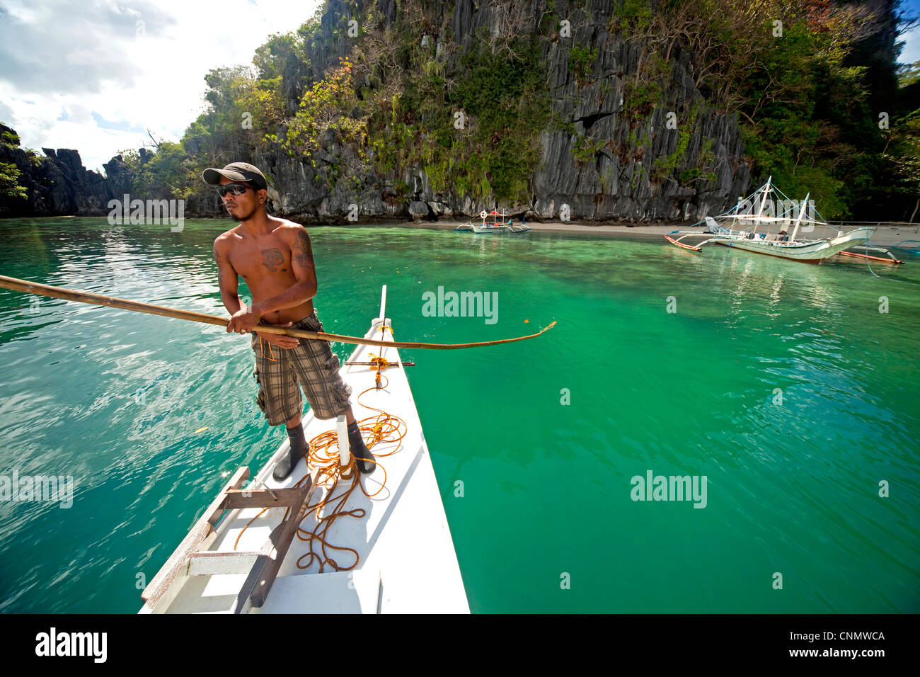 Boatsman in a traditional outrigger boat near the coast of mainland Palawan, El Nido, Palawan, Philippines, Asia Stock Photo