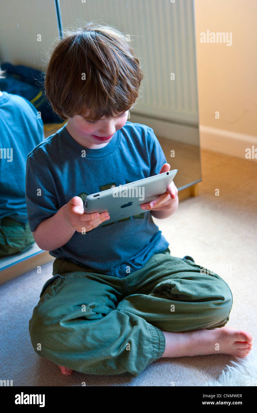 Boy playing with i-pad Stock Photo - Alamy