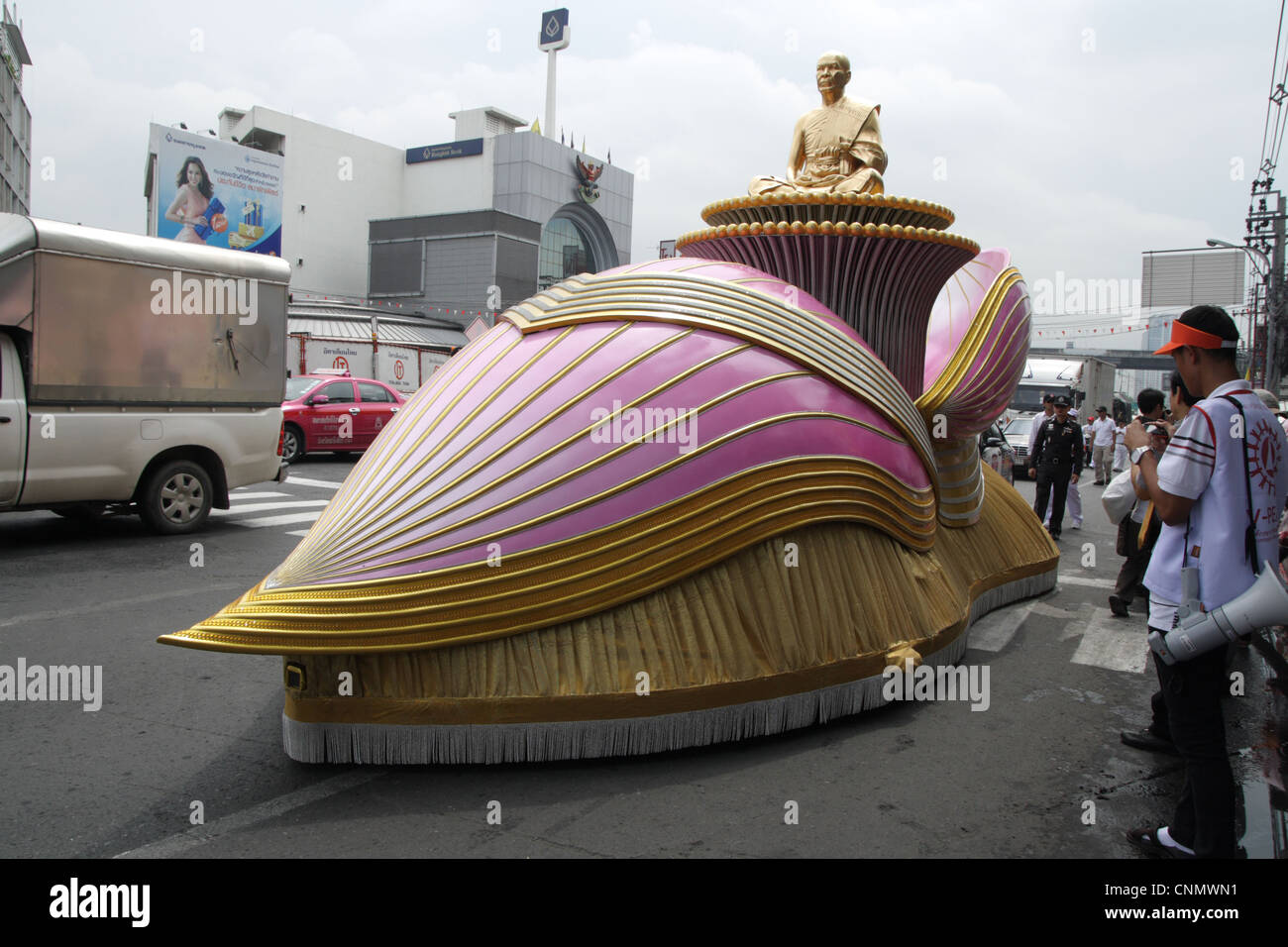 A fancy car carrying Golden Buddha statue during  pilgrimage ceremony , walking through inner areas of Bangkok Stock Photo