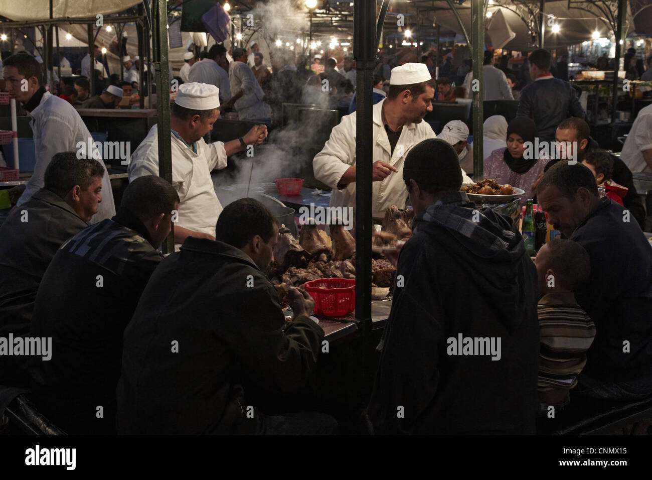 Street vendors serving lambs heads at food stall, in market at night, Marrakech, Morocco, february Stock Photo