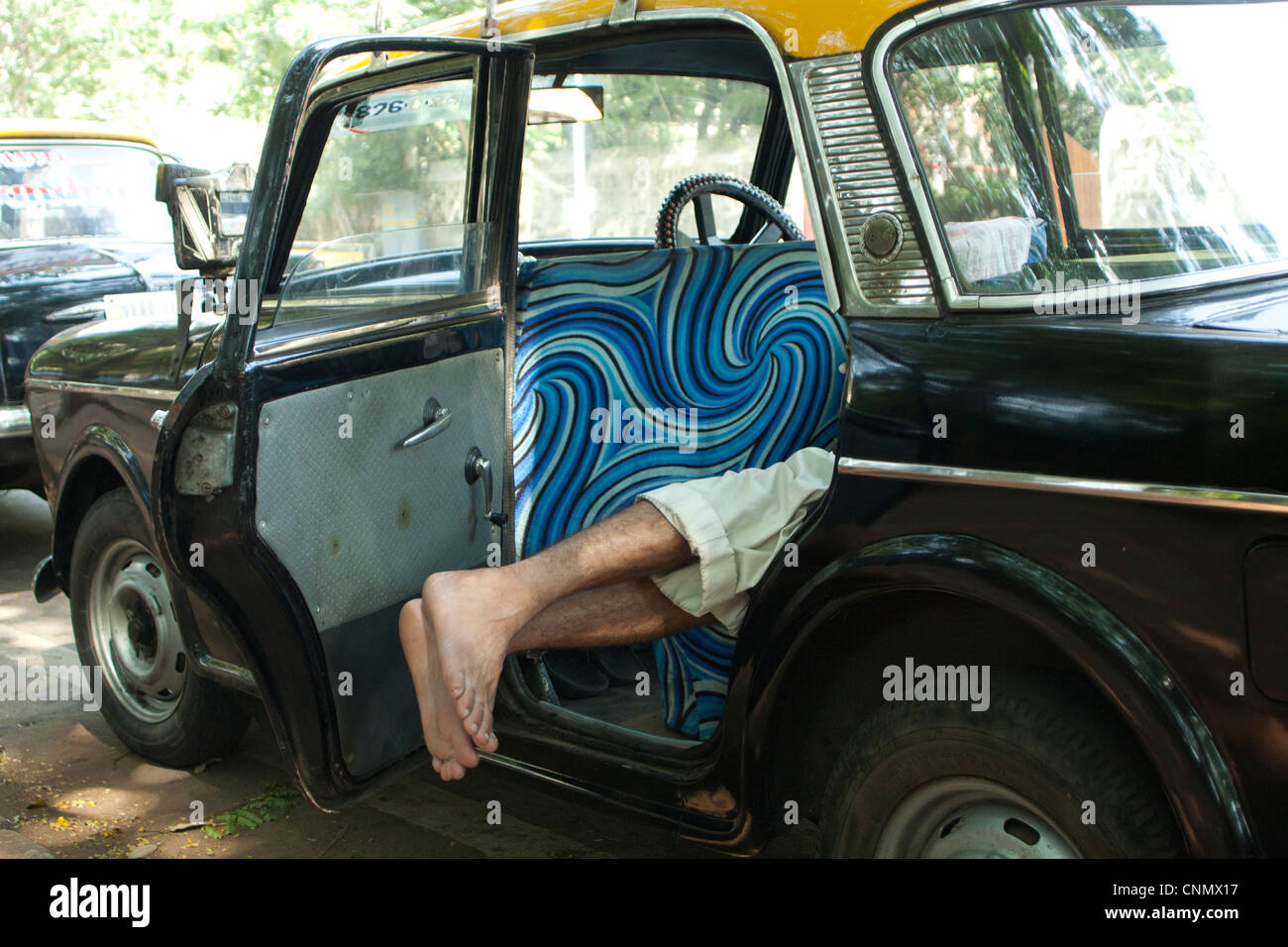 Taxi driver sleeping on back seat of cab, India Stock Photo Alamy