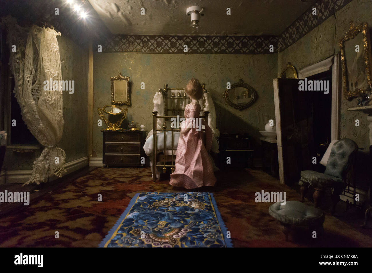 This stock photo showcases the intricate and ornate interior of a Victorian-style old doll's house, complete with miniature furniture and decor reminiscent of the 19th century. The attention to detail in the design captures the elegance and charm of traditional Victorian homes, providing a glimpse into the past through the miniature world of the doll's house.