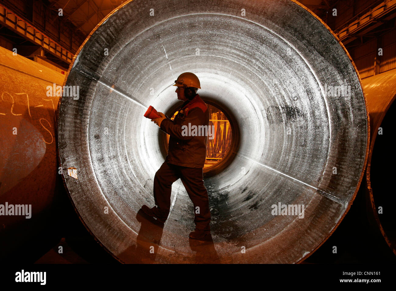 Worker at steel tubes fabricator inspects large pipeline for The North Sea Gas fields Stock Photo