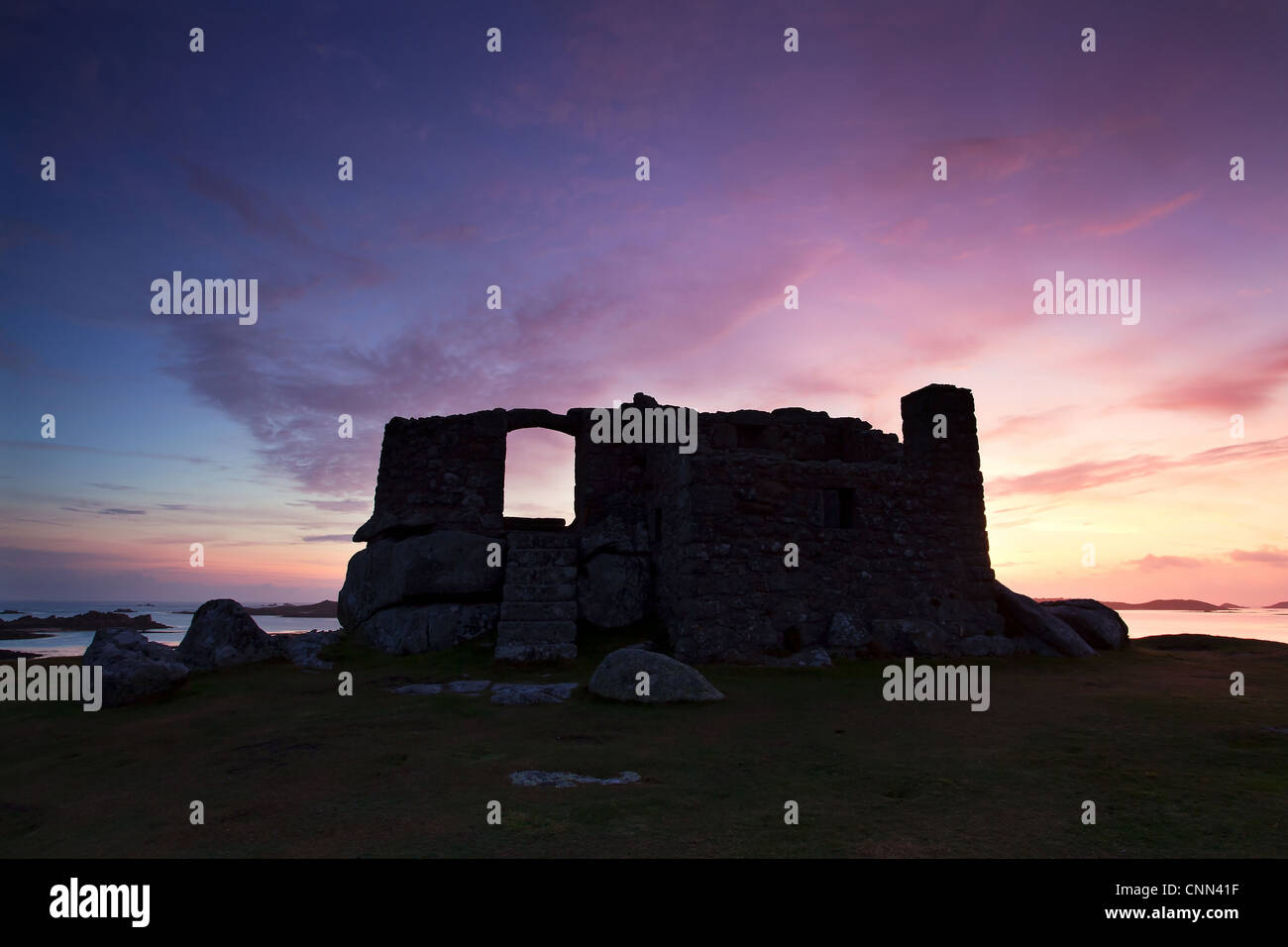 16th century fort built defend harbour silhouetted sunrise Blockhouse Block Point between Green Porth Cook's Porth Old Grimsby Stock Photo