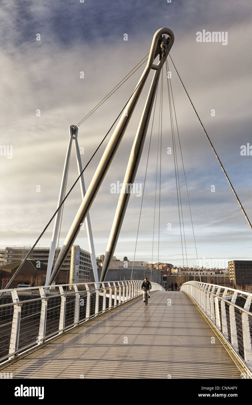 Man on bicycle crossing footbridge over river, Newport City Footbridge