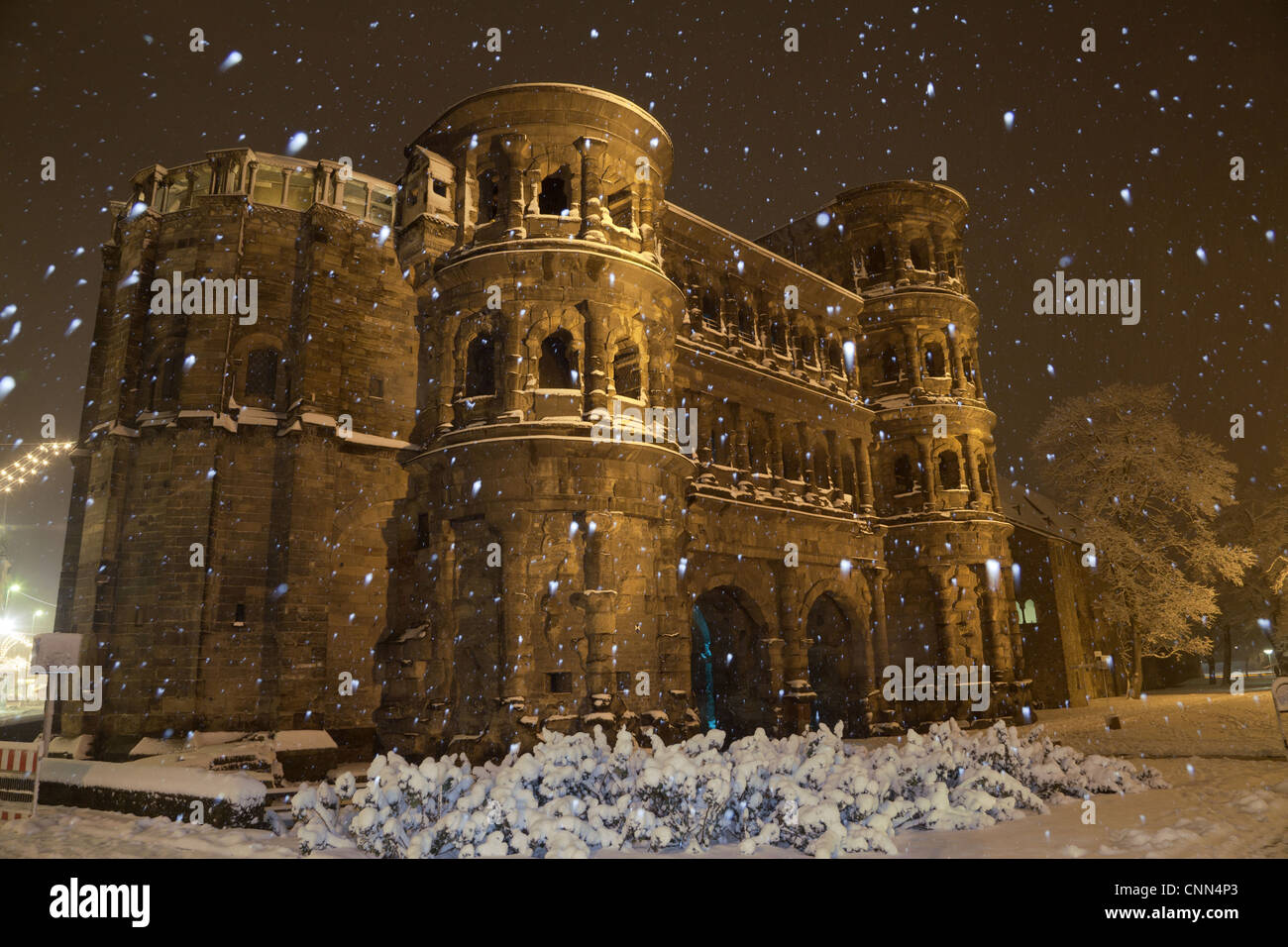 Roman city gate illuminated during snowfall at night, Porta Nigra, Trier, Rhineland-Palatinate, Germany, december Stock Photo