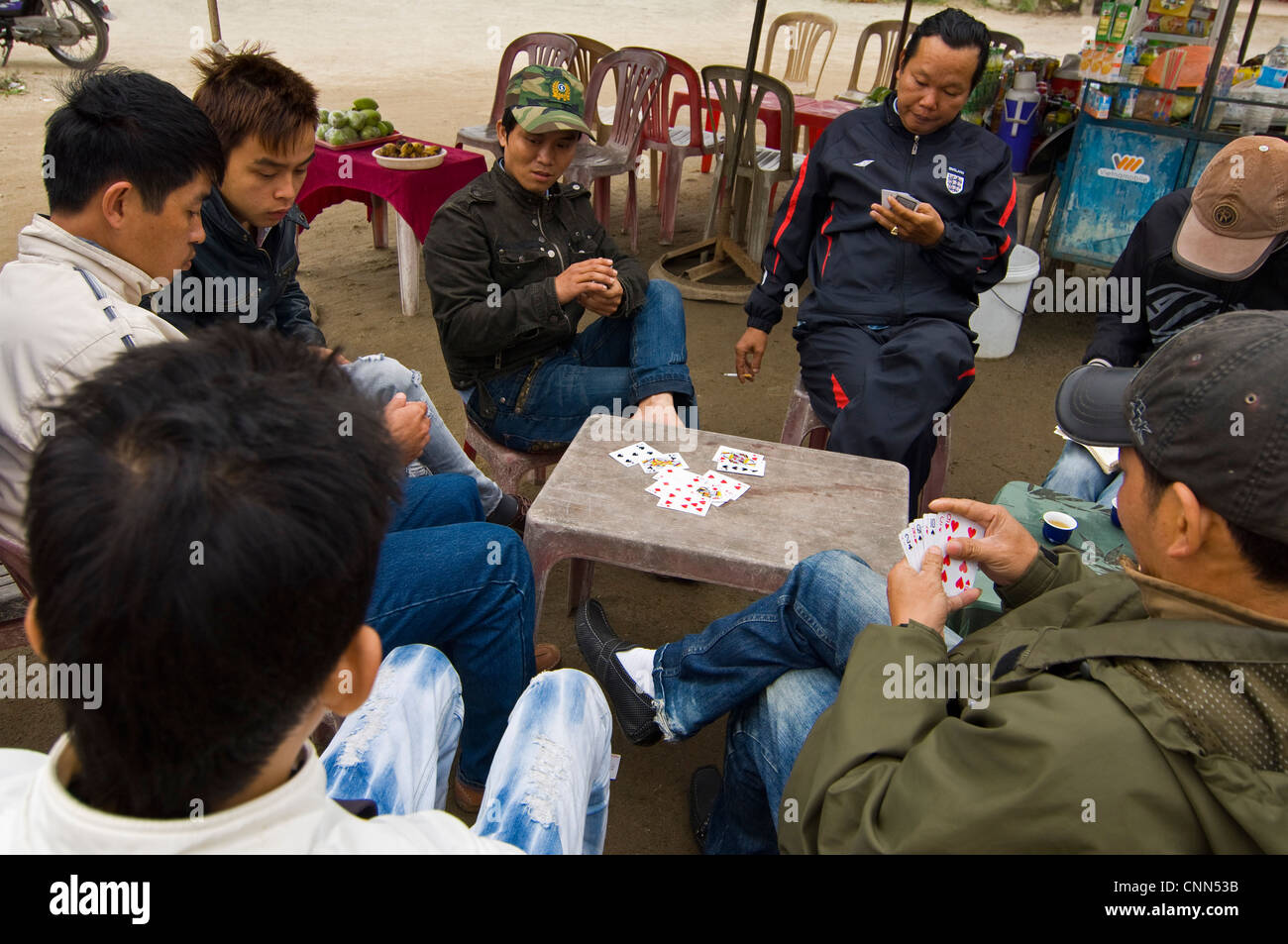 Horizontal view of a group of Vietnamese men playing a game of cards in