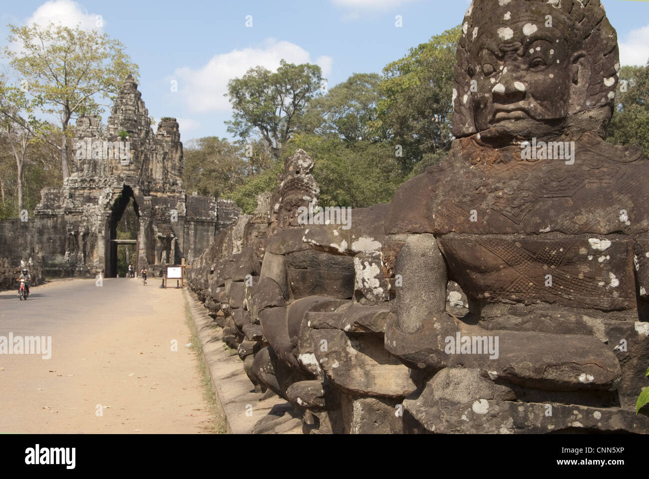 Sculptures of Asuras (demonic monsters) lining road to gate tower of Khmer temple, South Gate, Angkor Thom, Siem Riep, Cambodia Stock Photo