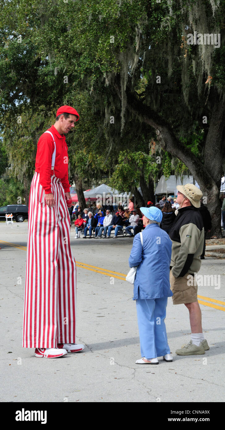 Man on stilts talks to visitors at the 50th annual Art Fiesta, New